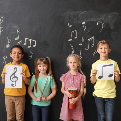 Children standing in front of a blackboard in music class